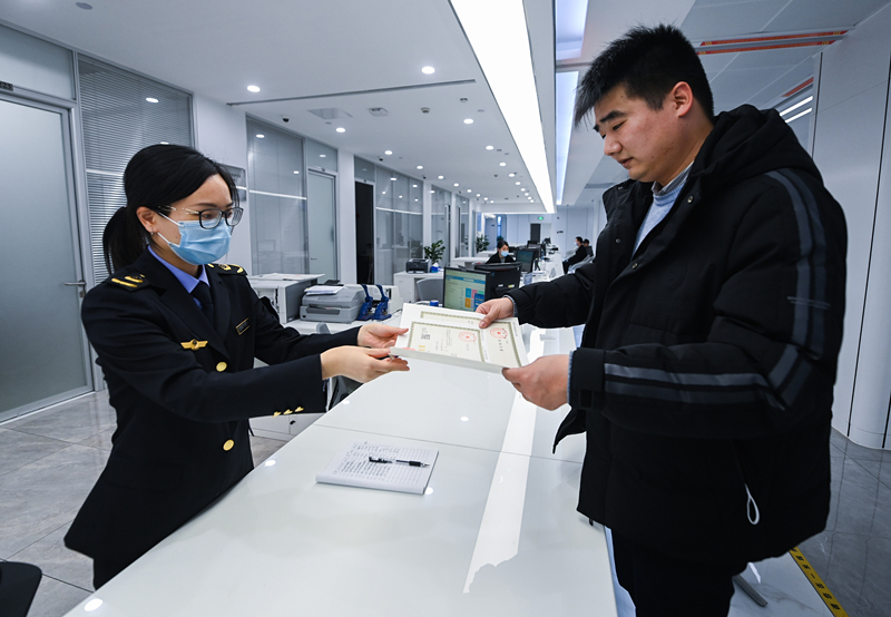 2023年2月8日，浙江省湖州市吴兴区，企业负责人在中小微企业一站式服务平台领取营业执照。